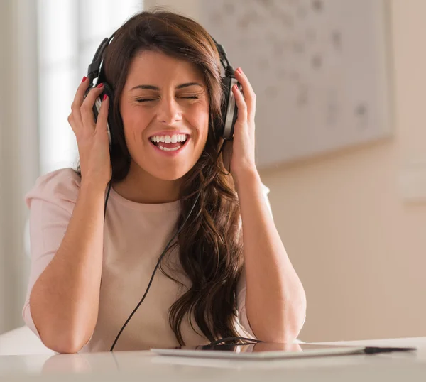 Kvinna lyssnar på musik på hörlurar — Stockfoto