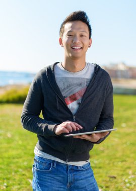 Elinde dijital tablet tutan genç adam