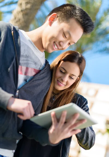 Casal jovem olhando para tablet digital — Fotografia de Stock