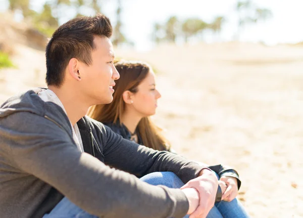 Junges Paar sitzt am Strand — Stockfoto