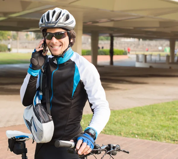 Joven ciclista masculino hablando por teléfono celular —  Fotos de Stock