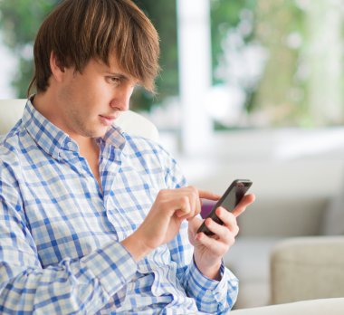 genç adam cep telefonu üzerinde çalışma