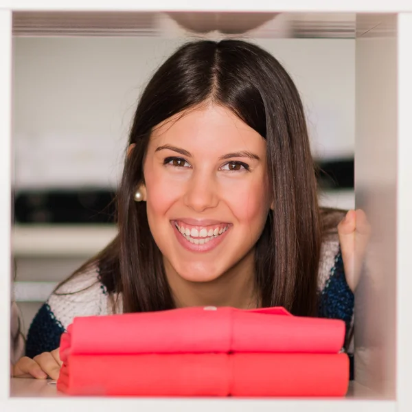 Mujer joven mirando a través de estante —  Fotos de Stock