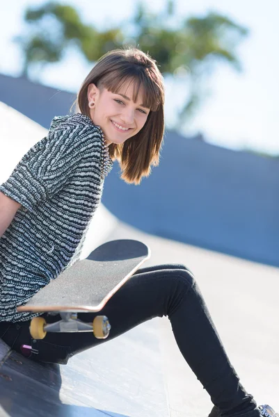 Šťastná žena, sedící s skateboard — Stock fotografie