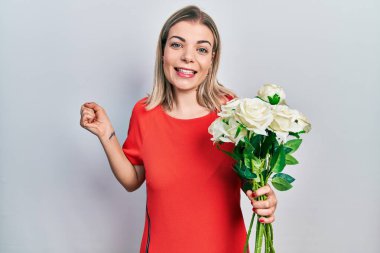 Güzel beyaz bir kadın elinde bir buket beyaz çiçekle gururla haykırıyor zaferi ve başarıyı kutluyor. 