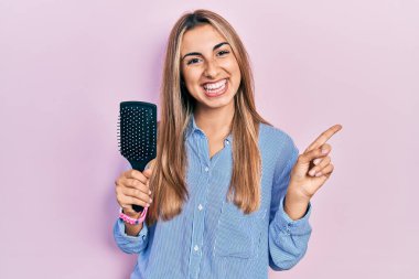 Güzel İspanyol bir kadın elinde saç fırçası, gülümsüyor. 