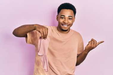 Çorap tutan genç Afro-Amerikalı adam gülümsüyor mutlu bir şekilde elini ve parmağını yana uzatıyordu. 