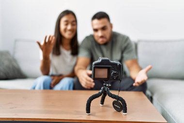 Oturma odasındaki kanepede oturan genç latin çift..