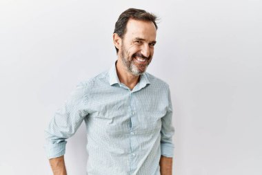 Orta yaşlı, sakallı, soyutlanmış arka planda duran, yüzünde gülümseme, doğal bir ifade olan İspanyol bir adam. Kendinden emin gülen. 