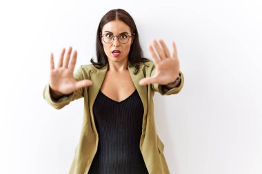 Genç esmer kadın izole edilmiş arka planda duruyor. Avuç içi hareketlerini durduruyor. Öfkeli ve hayal kırıklığı dolu bir ifade takınıyor. 