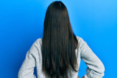 Gündelik kıyafetler giyen genç İspanyol kadın kolları vücudunda geriye doğru bakıyor. 