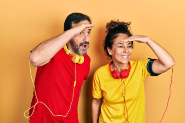 Orta yaşlı bir çift İspanyol kadın ve erkek spor giyer ve kol bandı takar. Çok mutlu ve gülümserler. arama kavramı. 