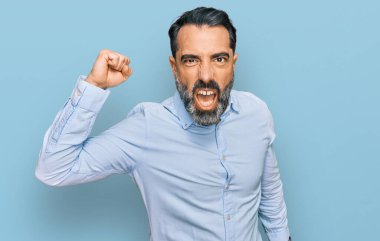 Orta yaşlı, sakallı, iş gömleği giyen kızgın, kızgın yumruğunu kaldıran öfkeli ve öfkeyle bağıran bir adam. öfke ve agresif konsept. 