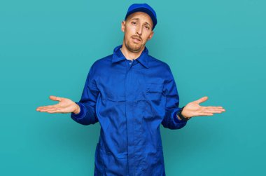 Sakallı, inşaatçı tulumu giyen kel adam hiçbir şeyden habersiz ve kolları açık, hiçbir fikri yok.. 