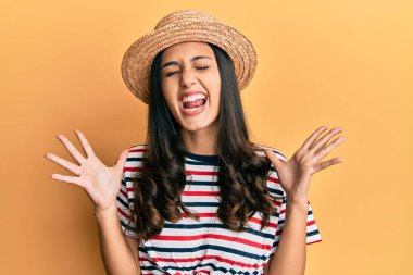 Yaz şapkası takan genç İspanyol kadın başarı için deli ve çılgınlığı kutluyor kollarını kaldırmış ve gözlerini kapatmış heyecanla bağırıyor. Kazanan konsept 