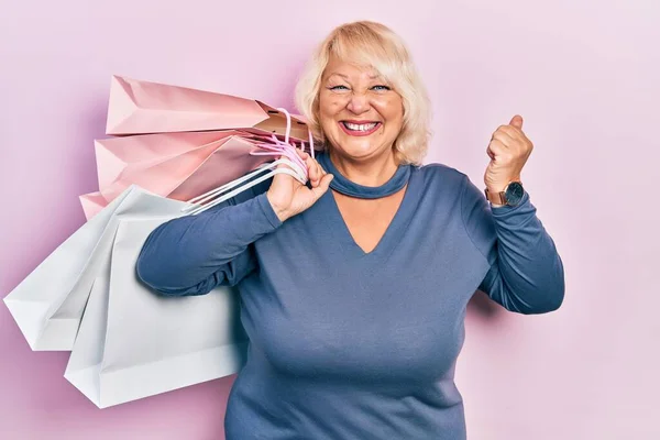 Mujer Rubia Mediana Edad Sosteniendo Bolsas Compras Gritando Orgulloso Celebrando — Foto de Stock