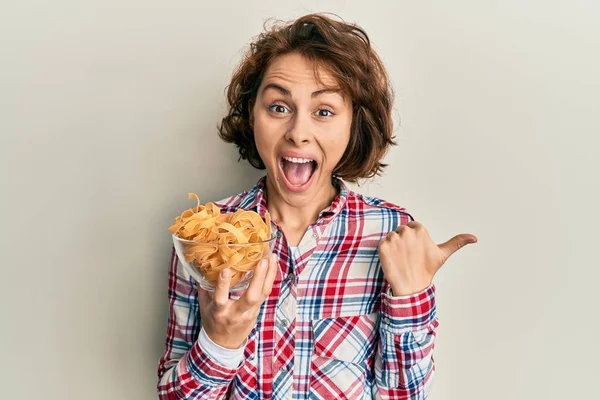 Ung Brunett Kvinna Håller Skål Med Italiensk Pasta Pekar Tummen — Stockfoto