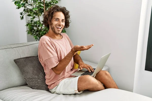 Evdeki Koltukta Oturan Spanyol Asıllı Genç Adam Dizüstü Bilgisayarını Kullanarak — Stok fotoğraf