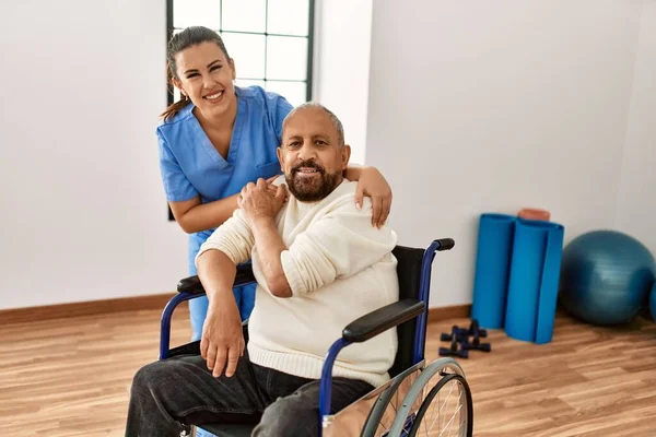 在康复诊所坐在轮椅上的老年人和老年护士 — 图库照片
