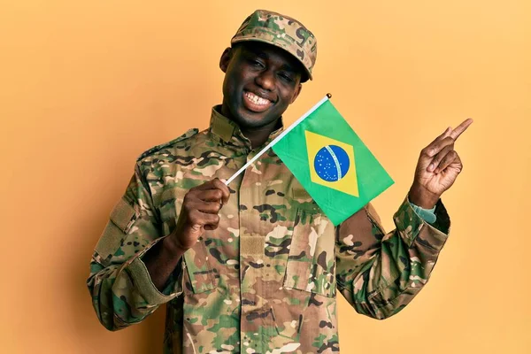Joven Hombre Afroamericano Vistiendo Uniforme Del Ejército Sosteniendo Bandera Brasileña —  Fotos de Stock