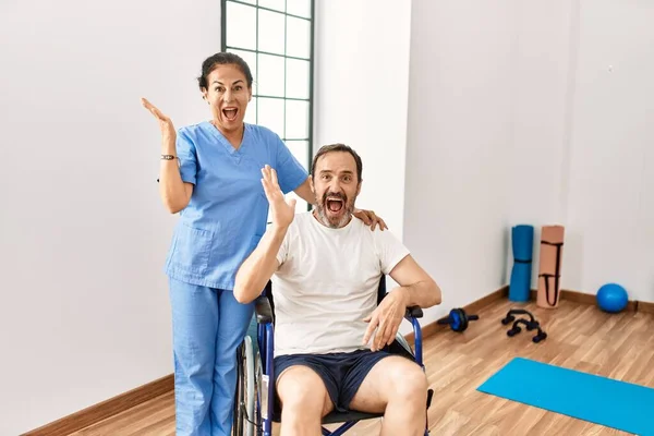 Hombre Hispano Mediana Edad Sentado Silla Ruedas Enfermera Clínica Rehabilitación —  Fotos de Stock