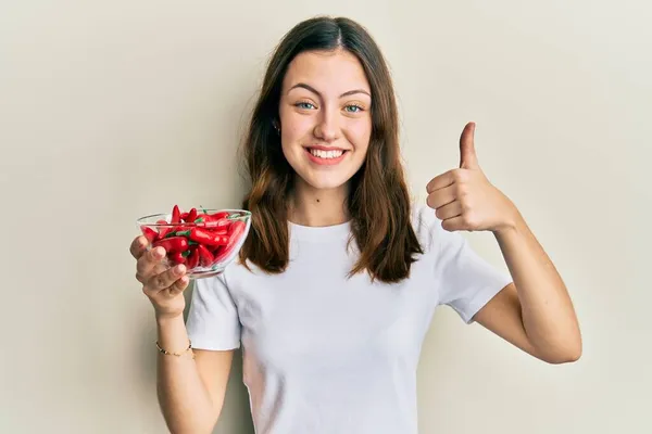 Młoda Brunetka Kobieta Trzyma Czerwony Papryka Uśmiechnięta Szczęśliwy Pozytywny Kciuk — Zdjęcie stockowe