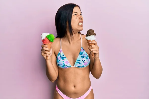 ビキニを着た若いラテン系の女性は アイスクリームを怒って怒って怒り狂った叫び 怒りで叫びます 怒りと攻撃的な考え方 — ストック写真