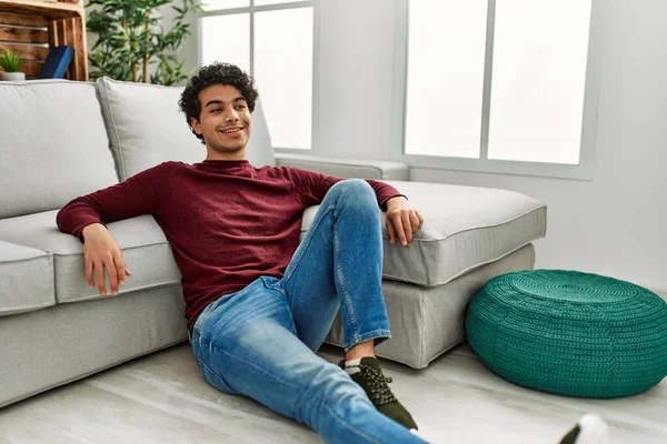 Joven Hombre Hispano Sonriendo Feliz Sentado Suelo Casa —  Fotos de Stock