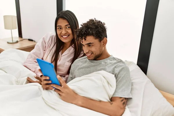 Jovem Casal Latino Sorrindo Feliz Usando Touchpad Deitado Cama Quarto — Fotografia de Stock