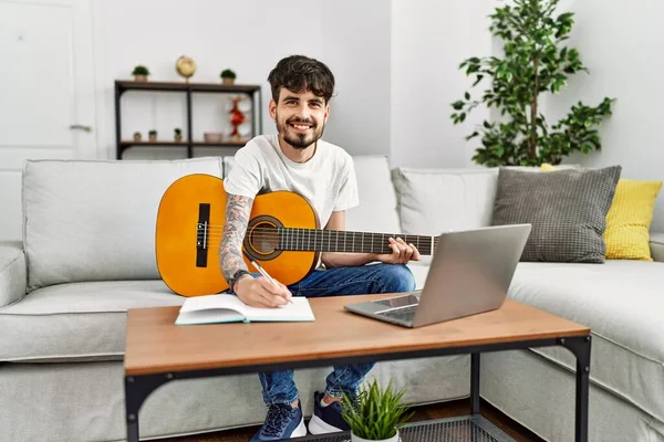Jovem Hispânico Tocando Guitarra Clássica Usando Laptop Casa — Fotografia de Stock