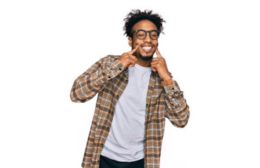 Sakallı, sıradan giyinmiş, gözlüklü, ağzı açık gülümseyen, parmakları açık, neşeli gülümsemeye zorlayan Afrikalı genç bir Amerikalı. 