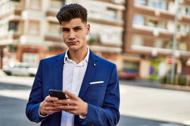 Sokakta akıllı telefon kullanan genç bir adam.