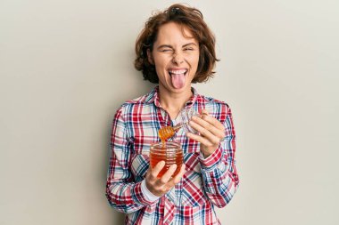 Genç esmer kadın elinde taze bal tutuyordu. Dilini çıkarıyordu. Komik bir ifadeyle mutlu.. 