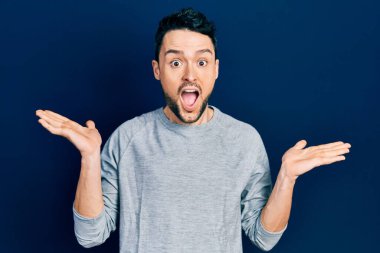 Sıradan kıyafetler giyen genç İspanyol adam çılgın ve başarıyı kollarını kaldırıp heyecanla haykırarak kutluyor. Kazanan konsept 