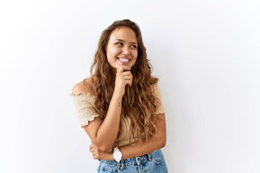 Güzel İspanyol kadın yalnız başına dikilirken arka planda kendine güvenen kolları çapraz gülümseyen ve çenesini kaldırmış kameraya bakıyor. Olumlu düşünmek. 