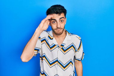 Gündelik kıyafetler giyen genç İspanyol adam, alında bir sorun olduğu için endişeli ve stresli, gergin ve kriz için endişeli. 