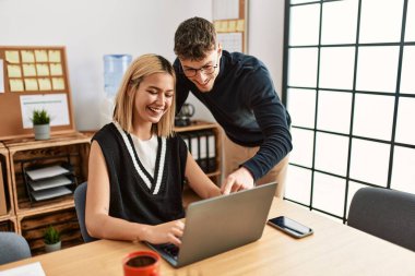 Ofiste dizüstü bilgisayarla çalışırken gülümseyen iki iş adamı..