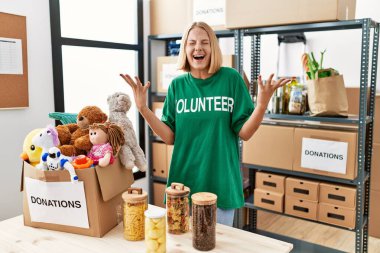 Bağışlarda gönüllü tişört giyen beyaz bir kadın kollarını kaldırmış ve gözleri kapalı heyecanla haykırarak başarının çılgınlığını kutluyor. Kazanan konsept 