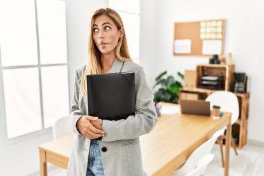 Ofisteki sarışın iş kadını dudaklarıyla balık suratı yapıyor. Çılgınca ve komik bir jest. Komik ifade. 