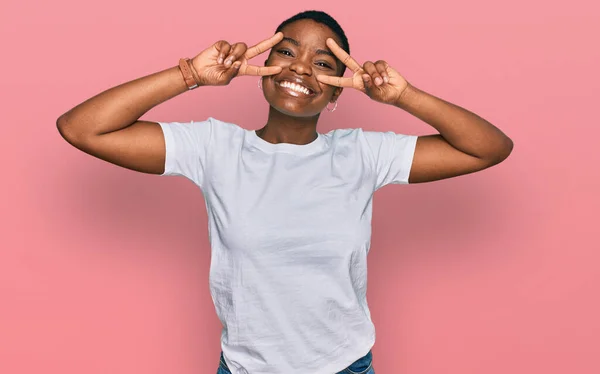 Молода Афроамериканська Жінка Білій Сорочці Зображає Мир Пальцями Обличчі Усміхаючись — стокове фото