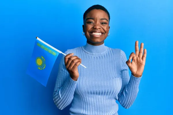 Young African American Woman Holding Kazakhstan Flag Doing Sign Fingers — Stock Photo, Image