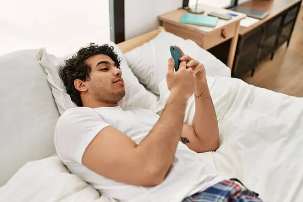 Junger Hispanischer Mann Lächelt Glücklich Auf Dem Bett Schlafzimmer Sitzend — Stockfoto