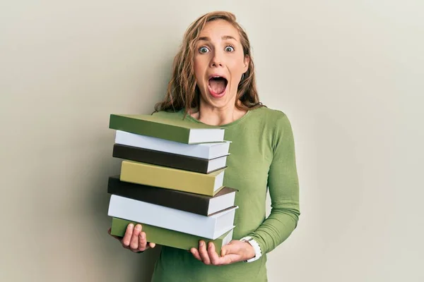 Jonge Blonde Vrouw Met Een Stapel Boeken Vieren Gek Verbaasd — Stockfoto