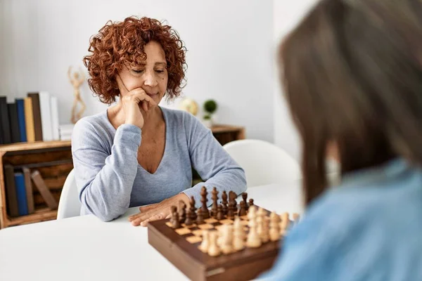Ώριμη Γυναίκα Παίζει Σκάκι Στο Σπίτι Σκέφτεται Στρατηγική Παιχνίδι — Φωτογραφία Αρχείου