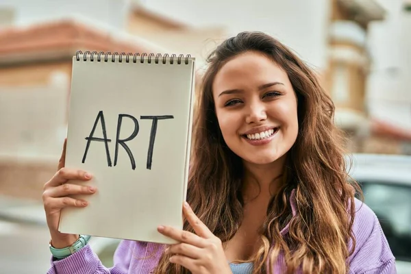 Joven Estudiante Arte Hispana Sonriendo Feliz Sosteniendo Cuaderno Ciudad — Foto de Stock