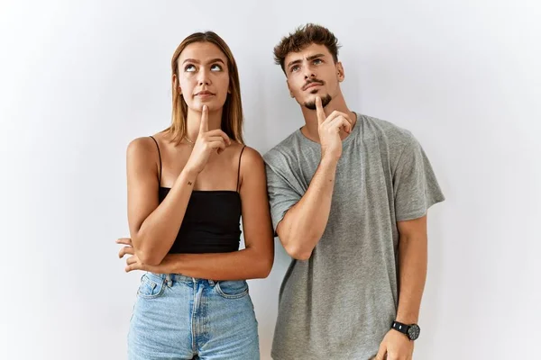 Young Beautiful Couple Standing Together Isolated Background Thinking Concentrated Doubt — Fotografia de Stock