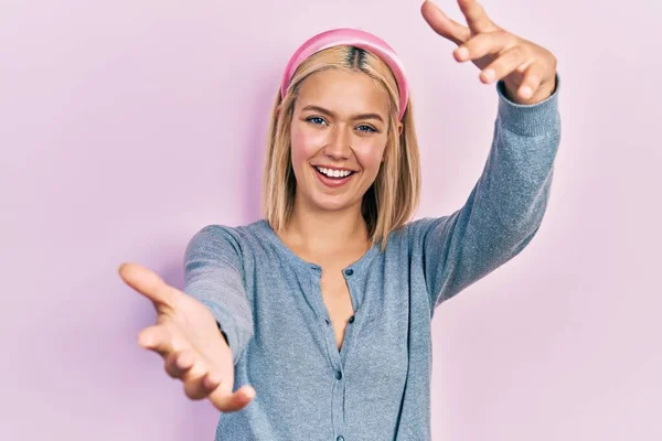 Hermosa Mujer Rubia Pie Sobre Fondo Rosa Mirando Cámara Sonriendo —  Fotos de Stock