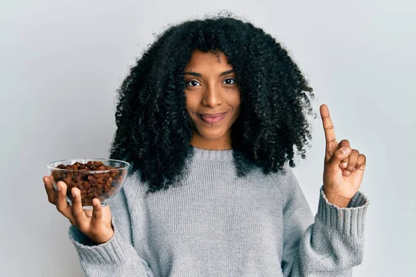 Afrikaans Amerikaanse Vrouw Met Afro Haar Houden Rozijnen Kom Glimlachend — Stockfoto