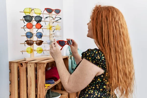 Mladá Zrzka Žena Drží Sluneční Brýle Nakupování Obchodě Oblečením — Stock fotografie