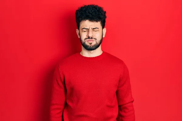 Młody Arabczyk Brodą Czerwonym Swetrze Nadętym Policzkiem Śmieszną Twarzą Usta — Zdjęcie stockowe